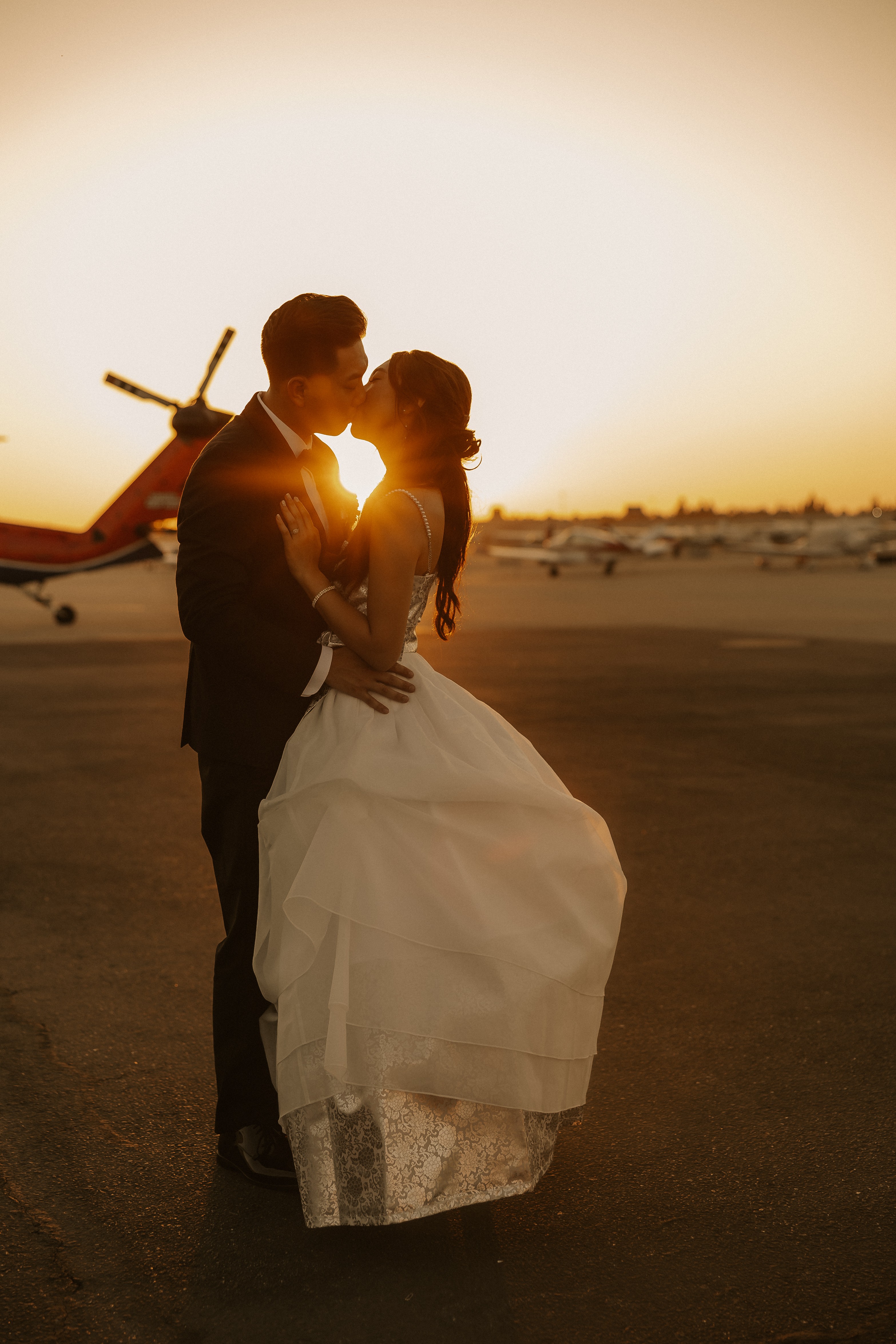 Dramatic sunset kiss at the airport with plane silhouette